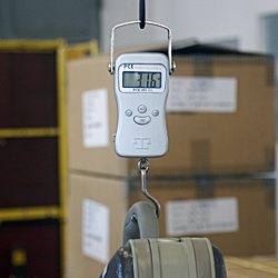 La balanza para colgar pesando una maleta.