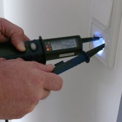 El comprobador de tensi�n PCE-TT1 comprobando un enchufe con iluminaci�n del punto de medici�n.