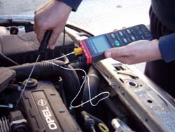 Indicador de temperatura PCE-T395 midiendo la temperatura del motor de un coche.