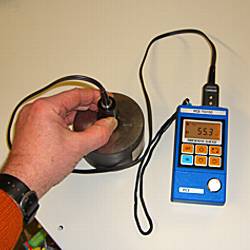 El medidor de espesores de material PCE-TG-100 midiendo una placa de acero.