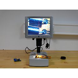 Aquí ve el microscopio para taller investigando una placa.