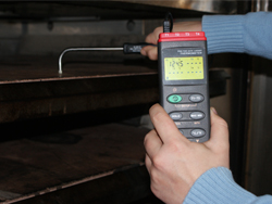 Termometro de contacto PCE-T395 midiendo la temperatura en las placas de un horno de cocci�n con una sonda.