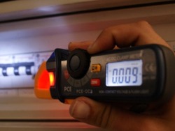 Voltmetro PCE-DC3 sin contacto, detectando el voltaje de un cuadro elctrico en condiciones de baja luminosidad.