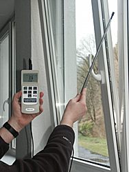 Anemómetro PCE-424 realizando una medición en el abertura de una ventana.