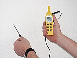 Higrómetro realizando una medición de la temperatura de una pared