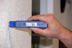 El medidor de humedad de material midiendo la humedad de una pared